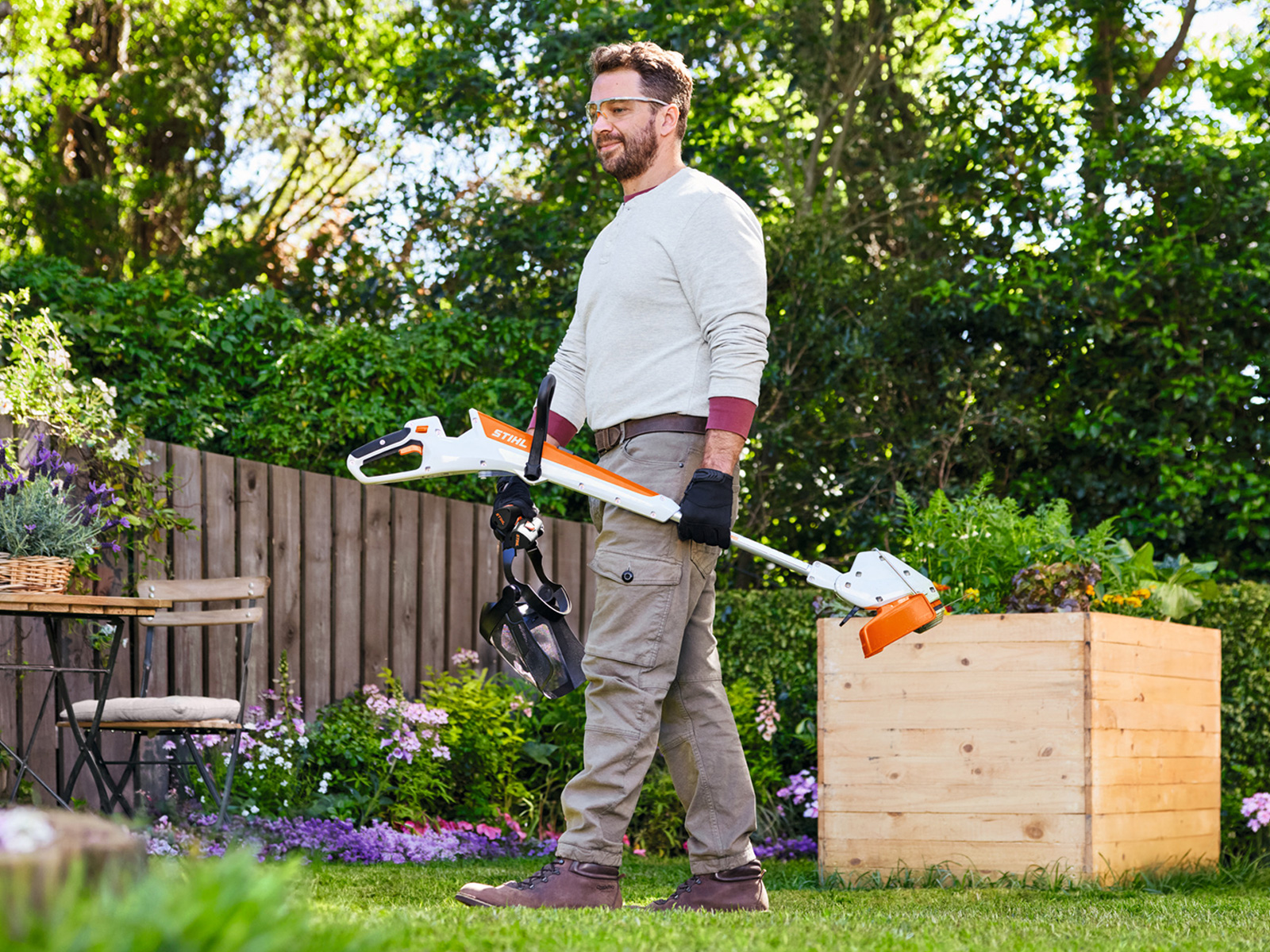 Mann mit STIHL Akku-Grasschneider FSA 30 und Gesichtsschutz