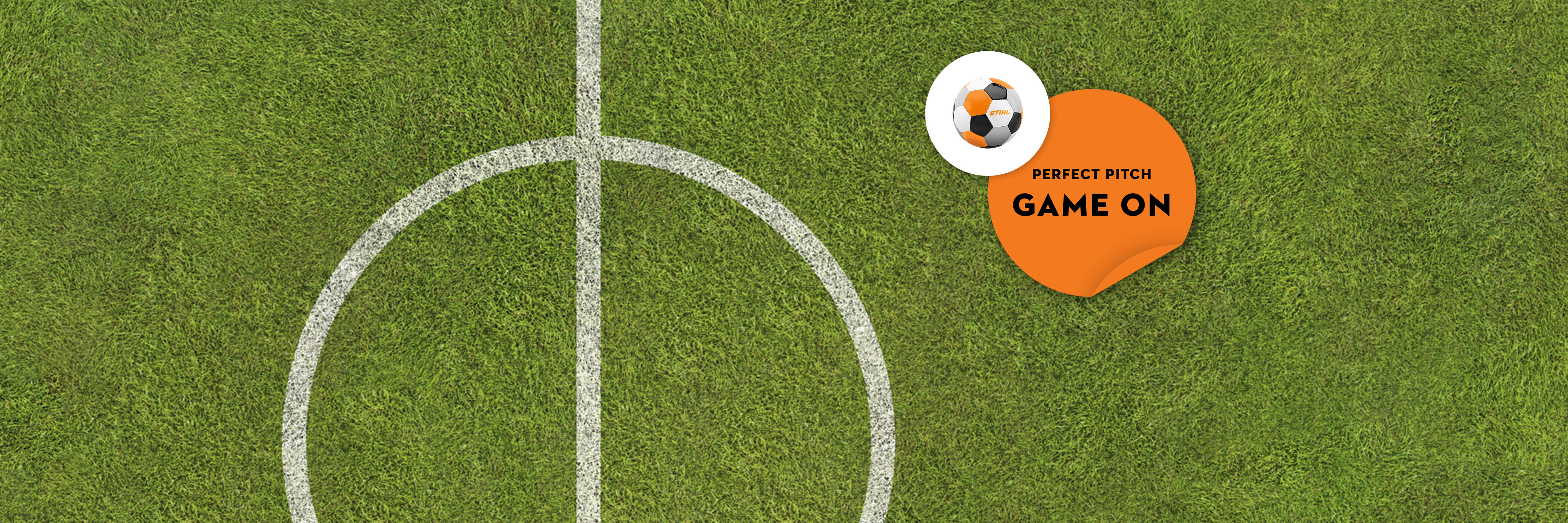 Draufsicht auf ein grünes Fußballfeld mit weißen Spielfeldmarkierungen, einem schwarz-weiß-orangen STIHL Fußball und einer orangefarbenen Grafik mit der Aufschrift "Perfect Pitch". Das Spiel läuft".
