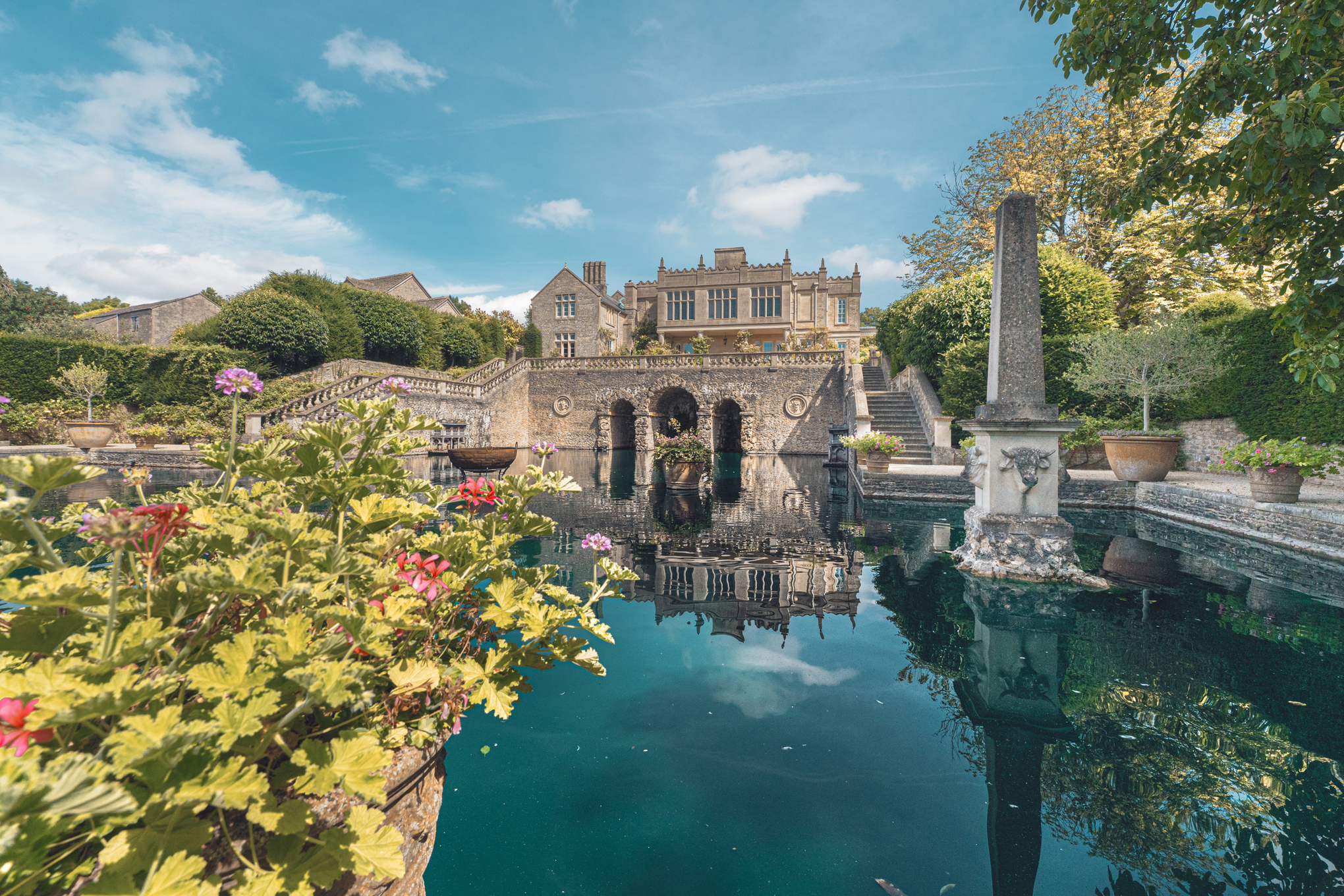 Großer Garten mit architektonischen Gebäuden und einem großen Teich