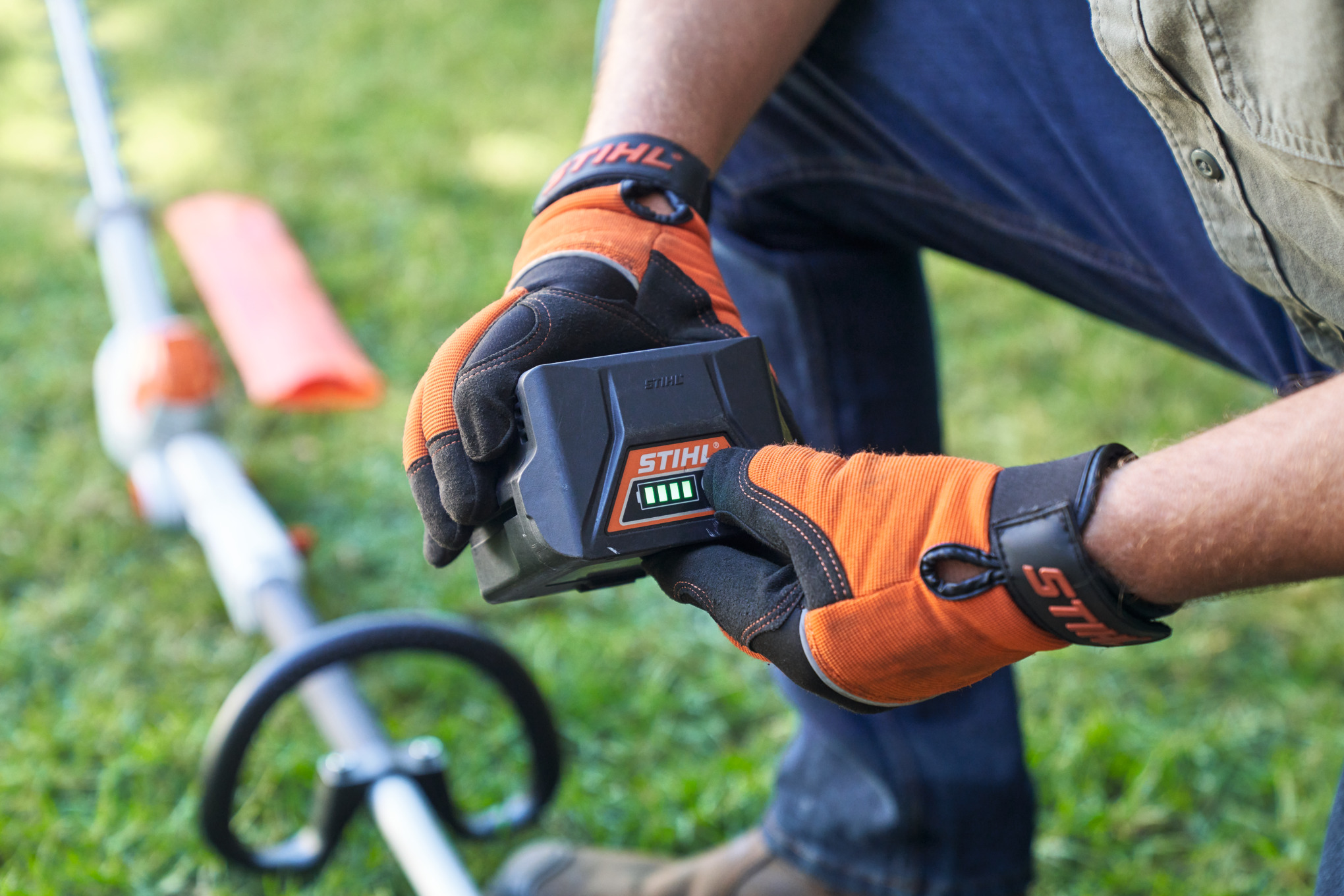Mann hält mit Schutzhandschuhen einen Akku in der Hand