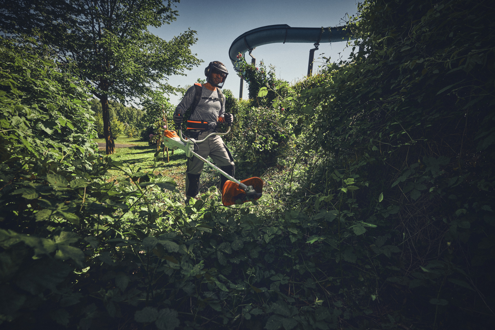 Mann mit akkubetriebenem Freischneider STIHL FSA 400 und Freischneidegerät beim Schneiden von Gestrüpp - Battery Pro - Frühjahr 2025