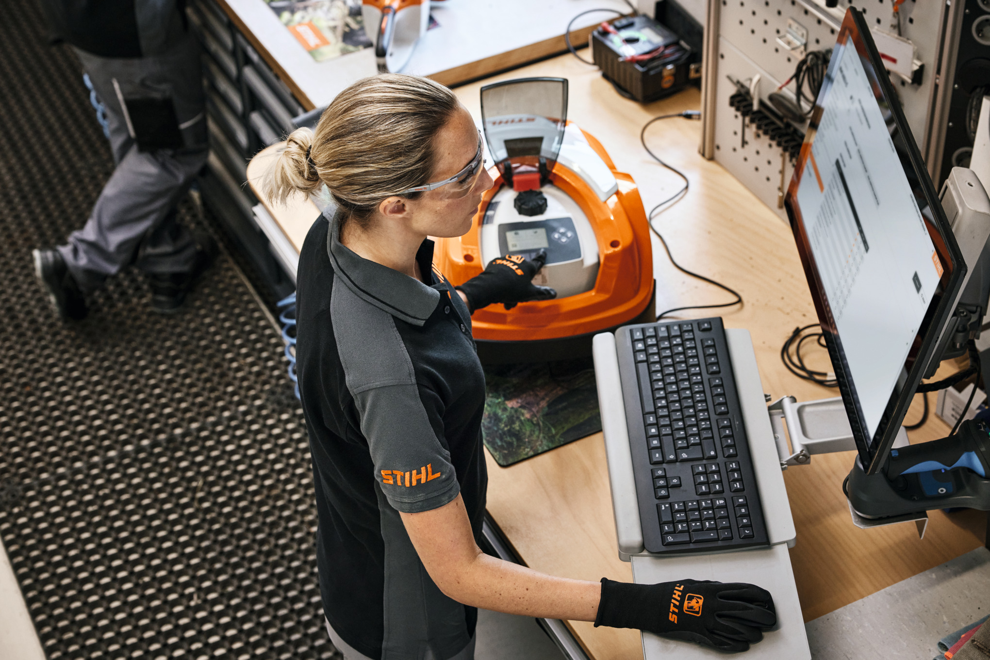 Frau steht in einer Werkstatt vor einem Computer