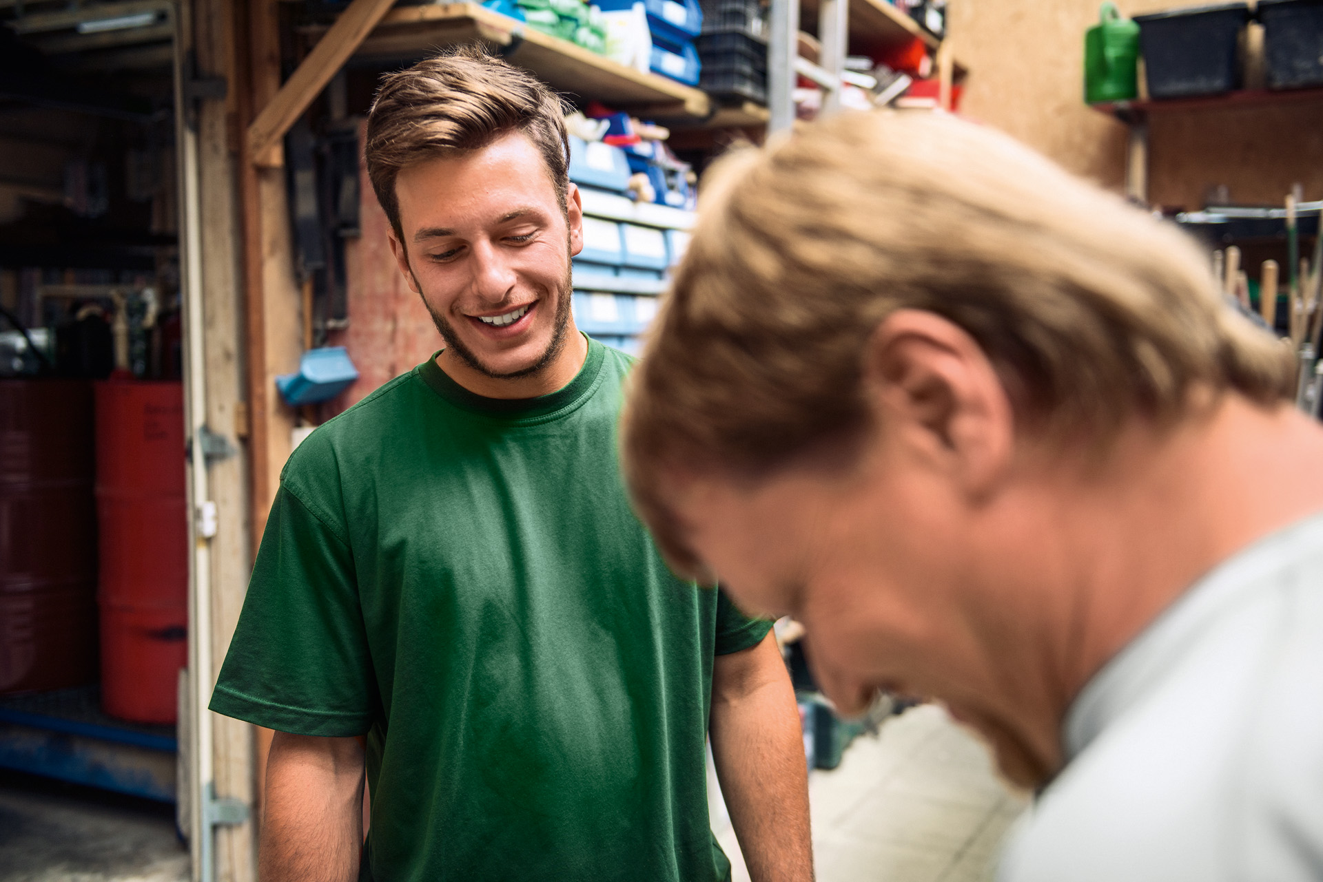 Zwei Männer lachen in einer Werkstatt