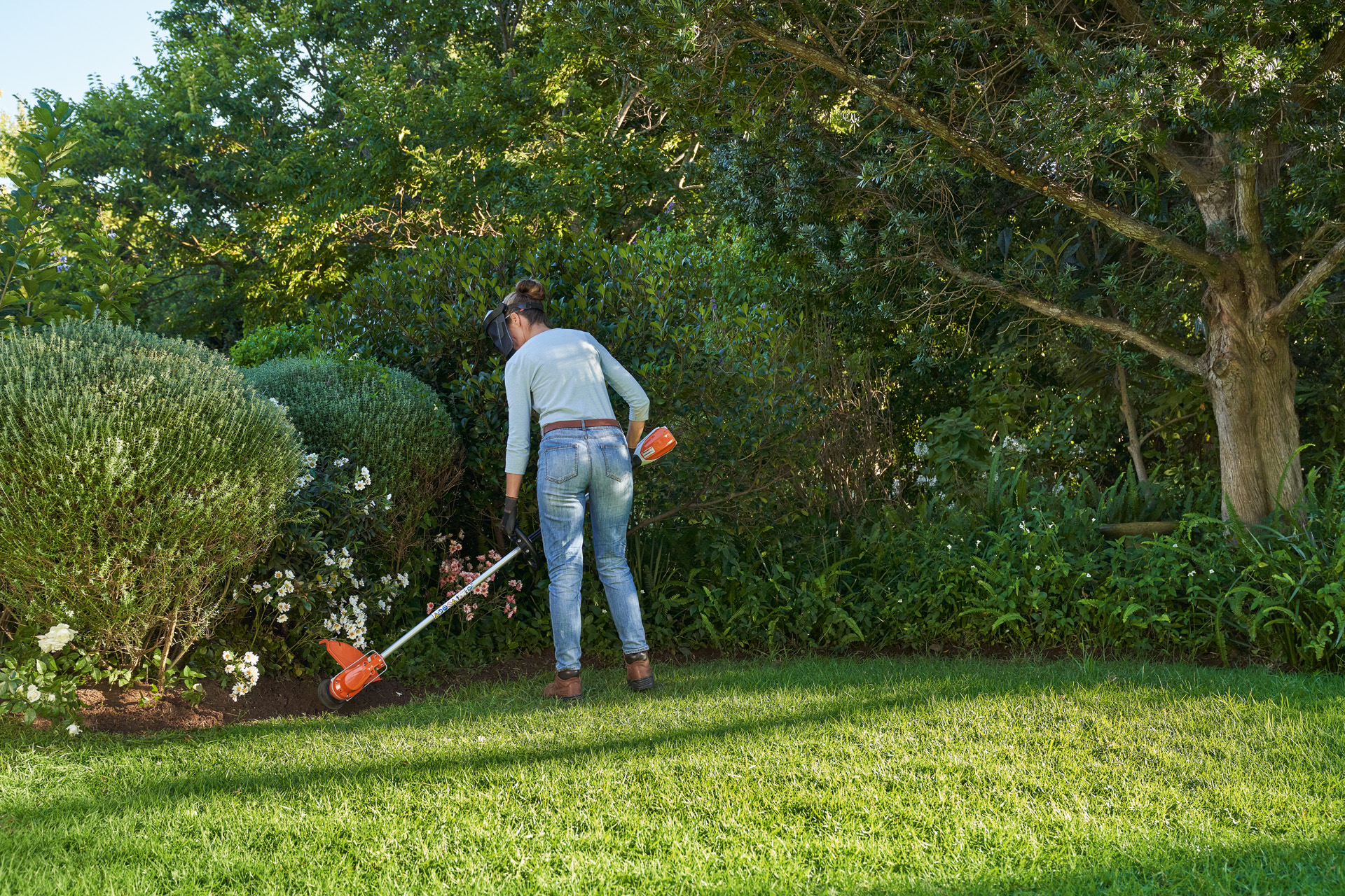 Frau pflegt englische Rasenkante mit STIHL Akku-Motorsense FSA 60