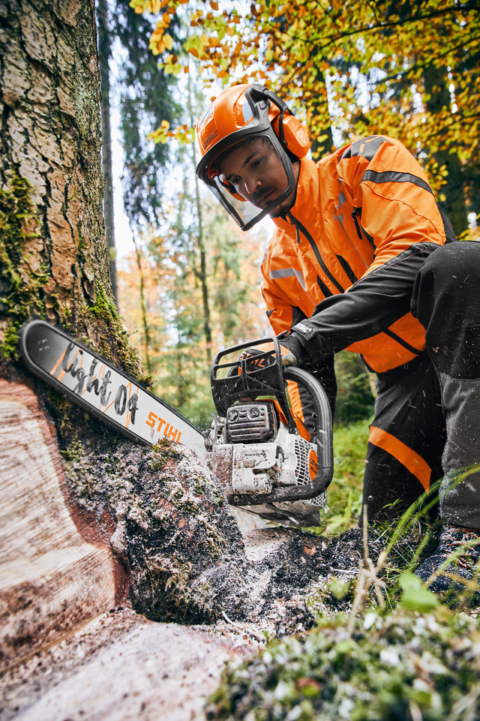 Mann mit STIHL Benzin-Kettensäge MS 261 C-M mit Führungsschiene Light 04 sägt an einem Baum