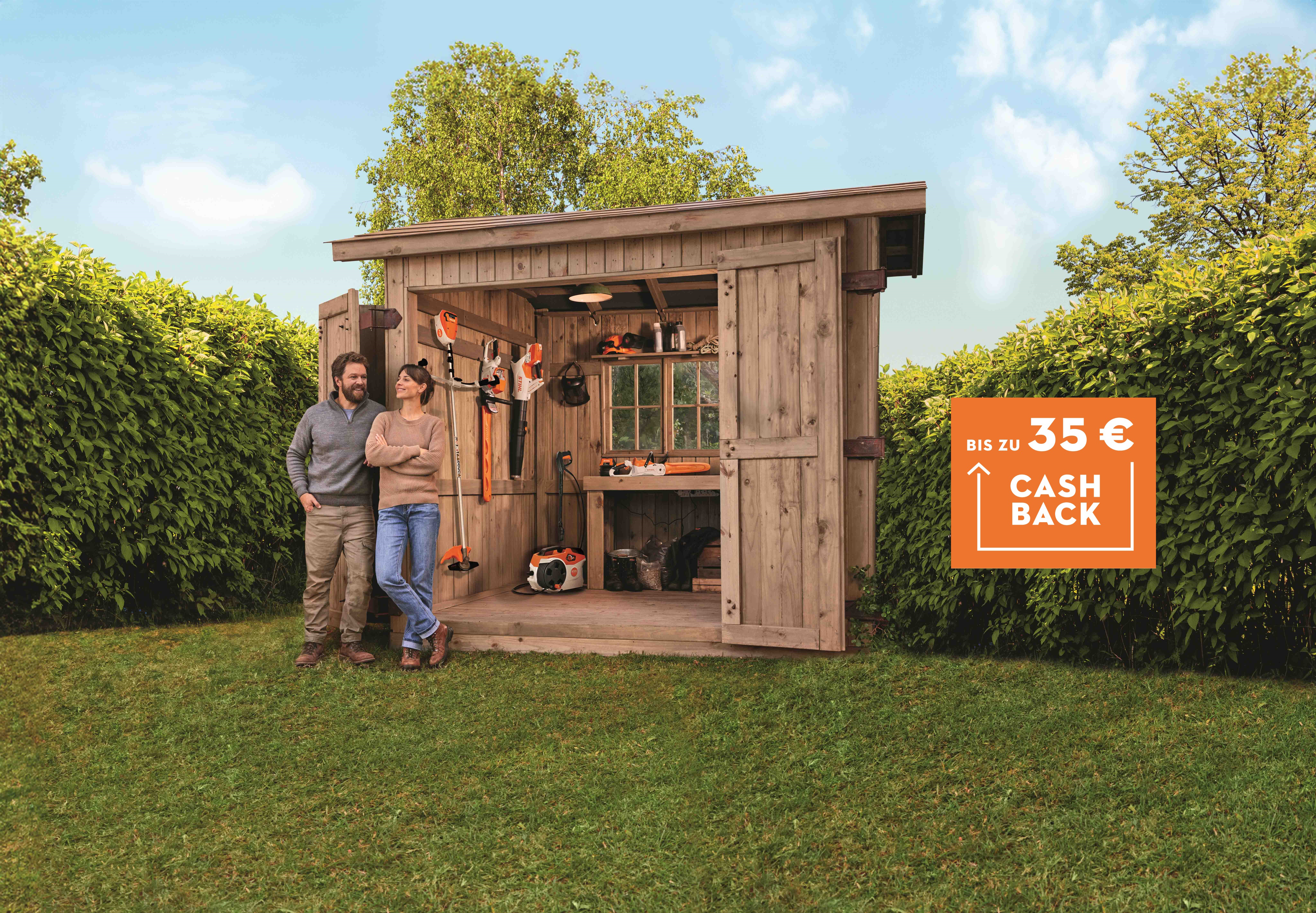 Diverse STIHL Akku Produkte aus dem Akku AK-System auf einem Rasen mit zwei Personen.