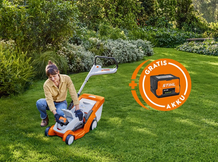 Eine Frau kniet auf dem Rasen und steckt einen STIHL AK 20 Akku in den RMA 235. Daneben ist ein Badge "Gratik Akku" zu sehen.