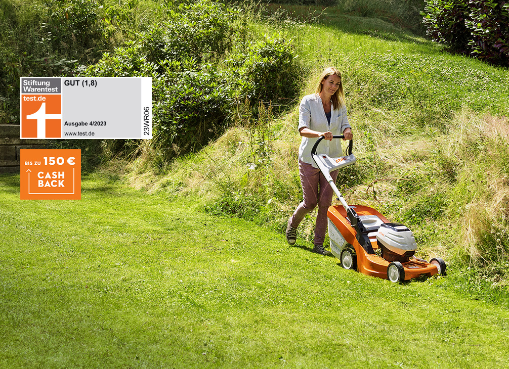Frau mäht den Rasen im Garten mit einem STIHL Akku-Rasenmäher RMA 443 C