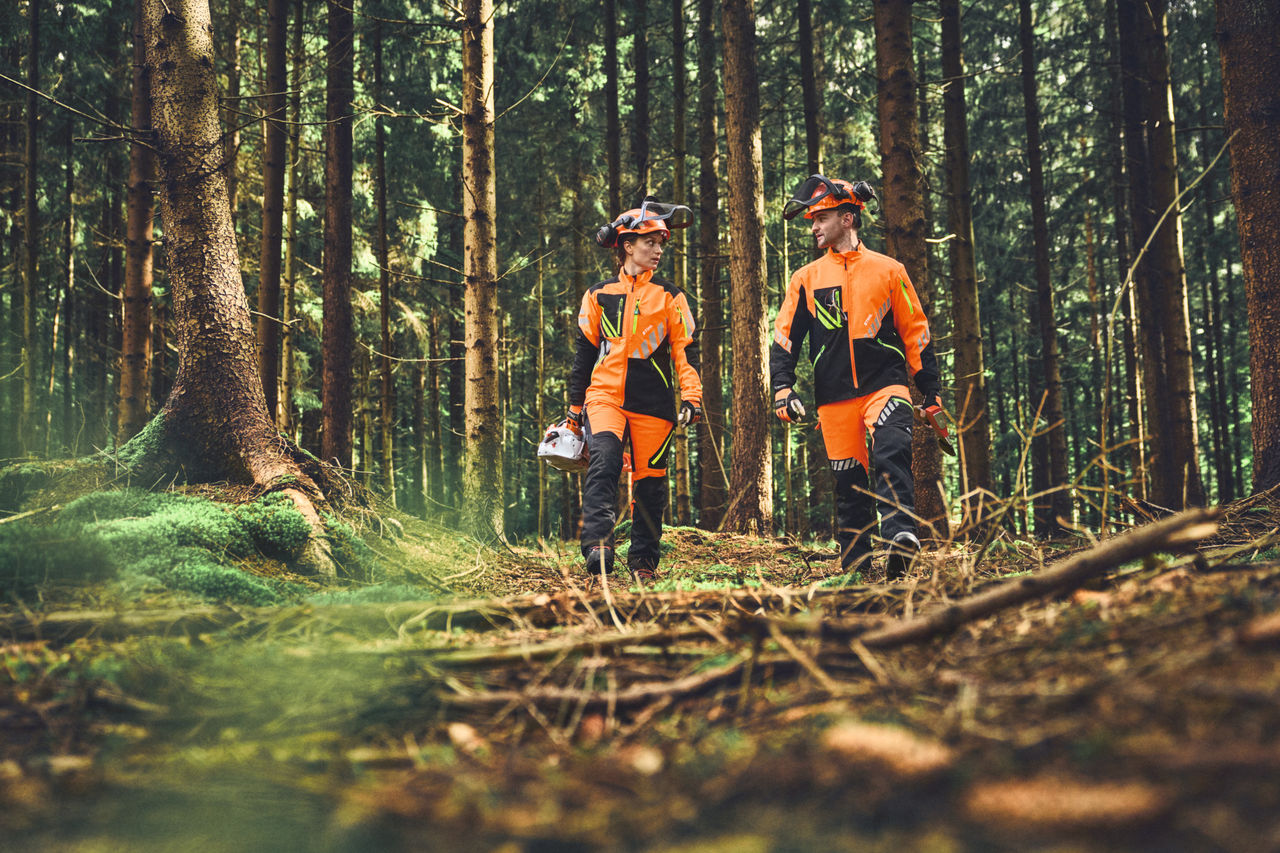 Zwei Forstarbeitende mit ADVANCE FlexTEC ShellTEC Kleidung im Wald
