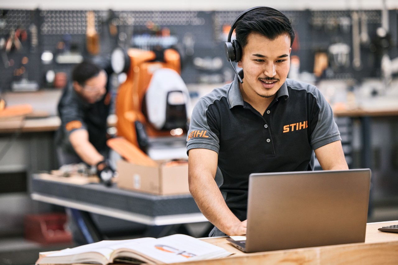 STIHL Mitarbeiterin oder Fachhandelsmitarbeiterin repariert eine Motorsäge