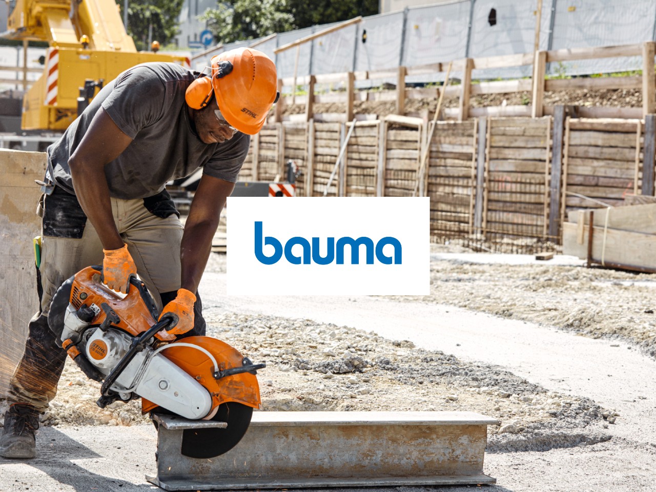 Im Vordergrund Logo der bauma, im Hintergrund Bauprofi mit STIHL Benzin-Trennschleifer beim Zerteilen eines Stahlträgers
